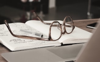 eyeglasses with gray frames on the top of notebook