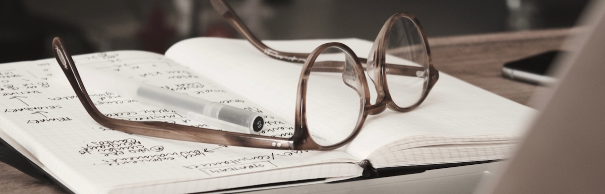 eyeglasses with gray frames on the top of notebook
