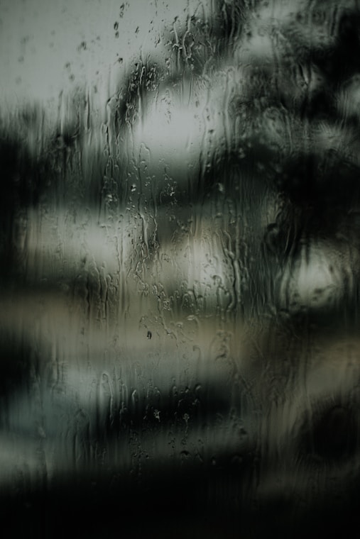 macro photography of water droplets on clear glass
