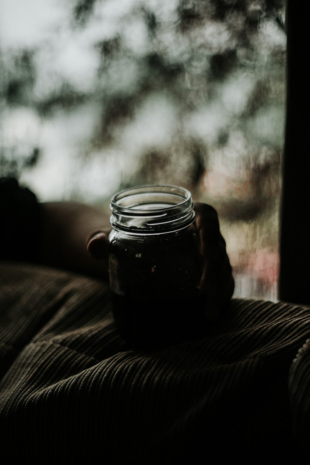 Person, die ein Glasgefäß in der Hand hält