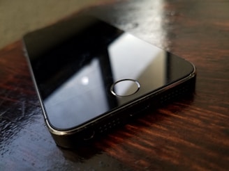 Close-up of a sleek refurbished smartphone with a vibrant screen on a wooden table