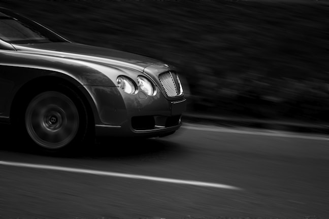 A dynamic video still of a luxury car in motion with cinematic contrast and gold accents.