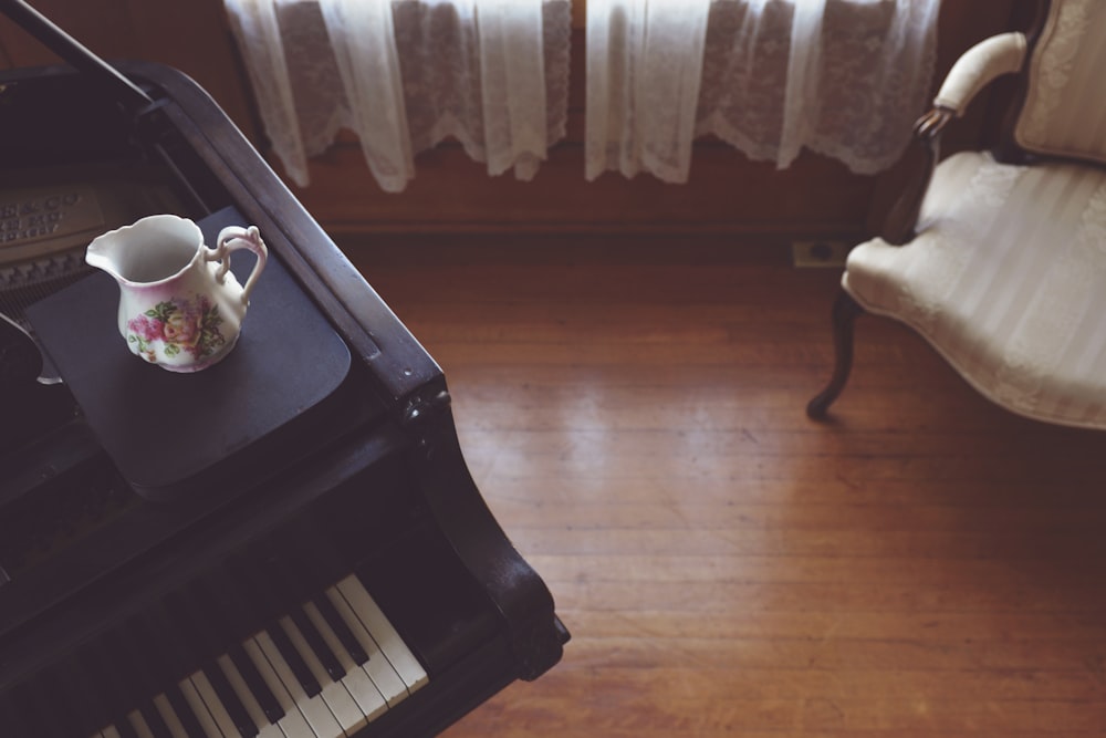 a coffee cup sitting on top of a piano