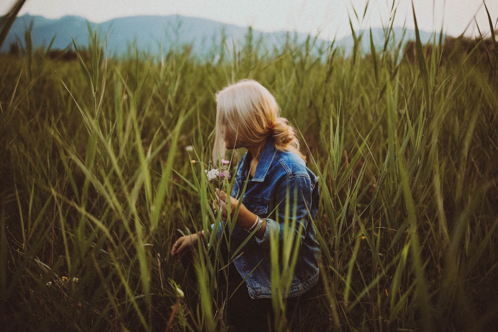 donna che cammina su piante a foglia verde durante il giorno