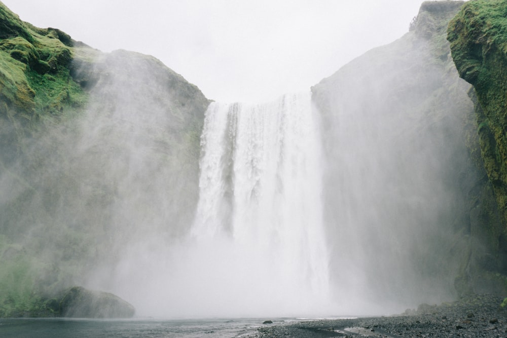 waterfall under cloudy sky