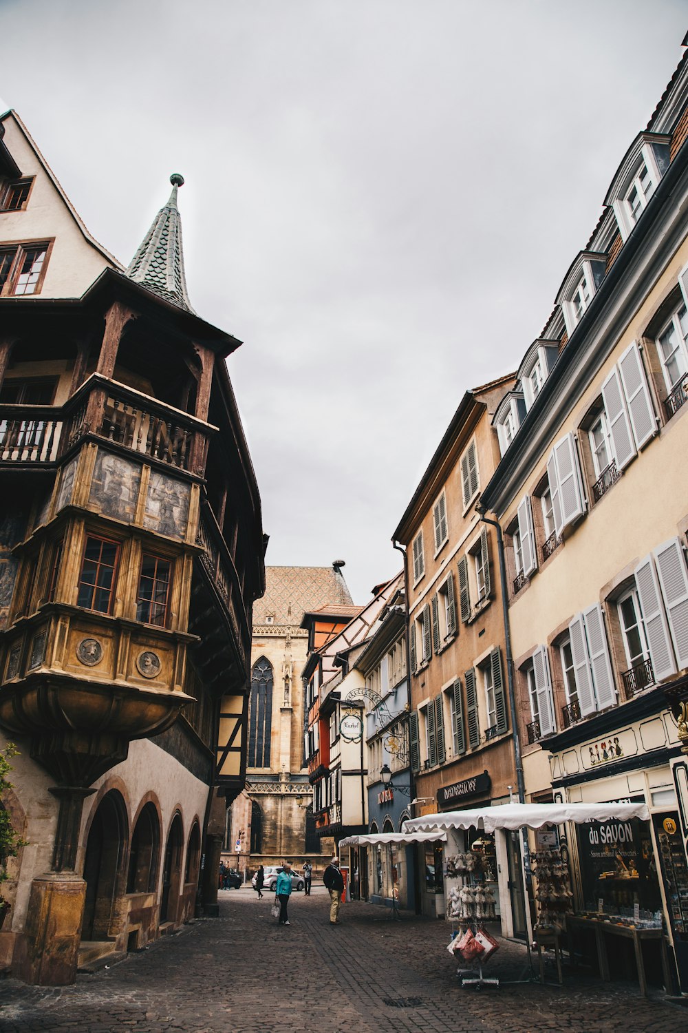 a narrow street with buildings and a clock tower