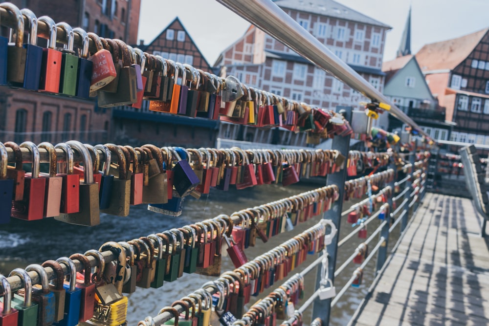 assorted-color padlock lot on balustrade beside canal