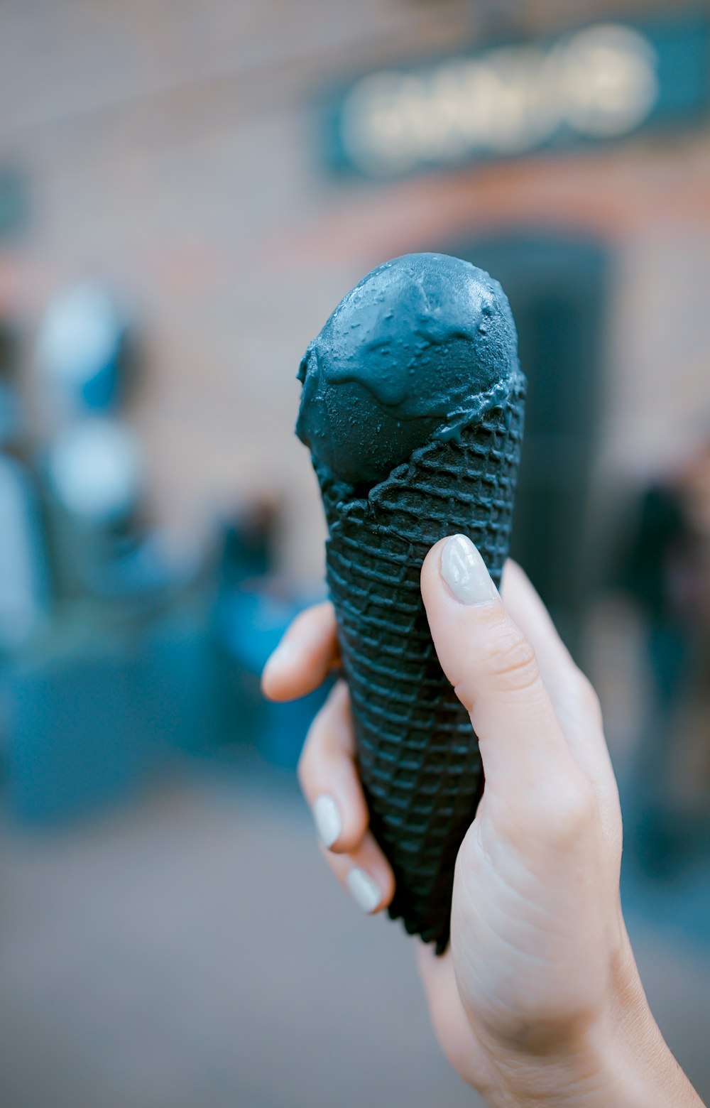 Persona sosteniendo un helado negro
