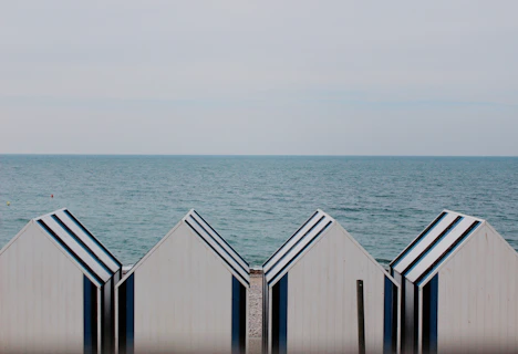 four white-and-blue sheds on shoreline