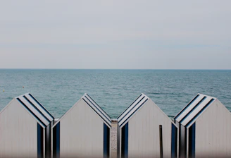 four white-and-blue sheds on shoreline
