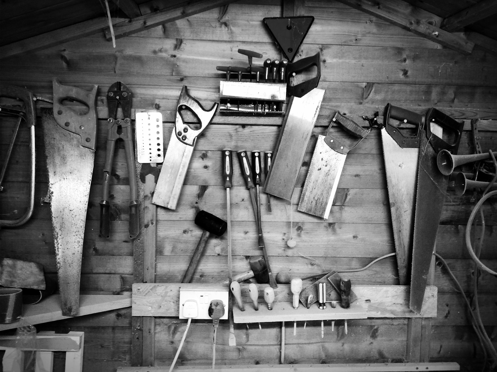 Grayscale photograph of assorted hand tools arranged on a surface