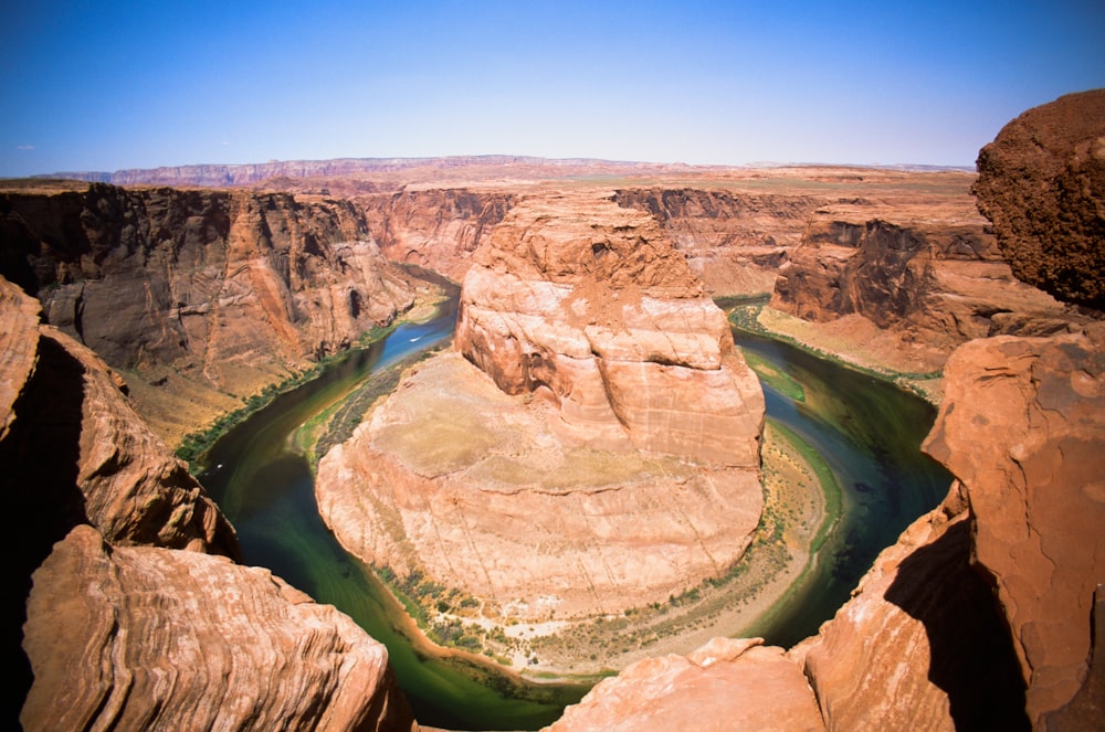 rock formation surrounded of body of water