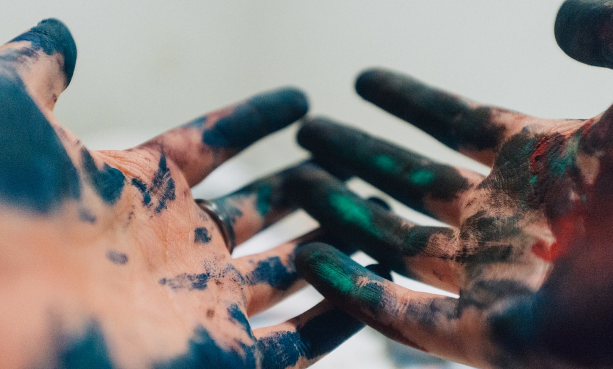 person hand with green and blue paint