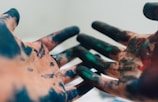 person hand with green and blue paint