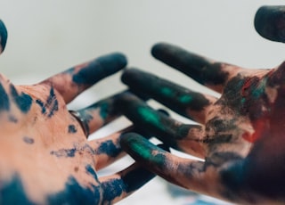 person hand with green and blue paint