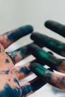 person hand with green and blue paint