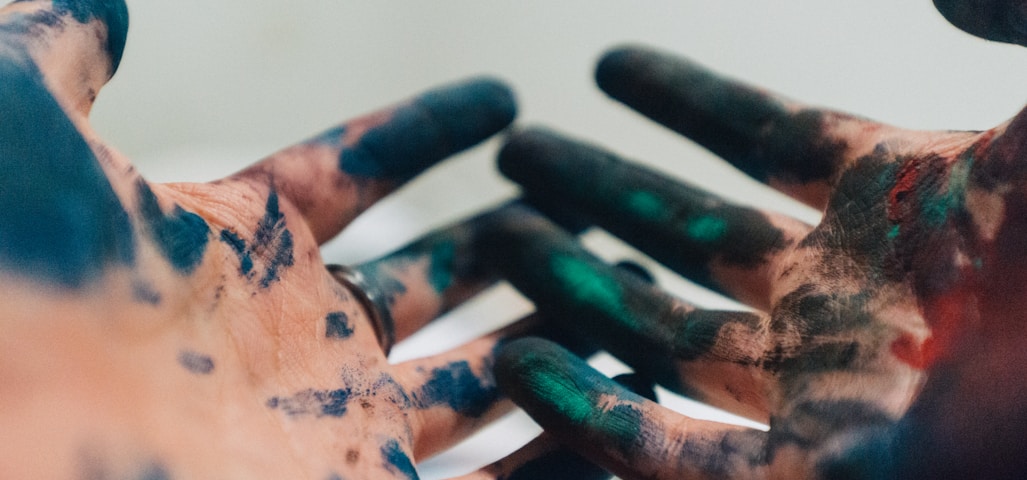 person hand with green and blue paint