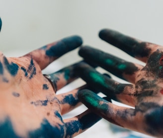 person hand with green and blue paint