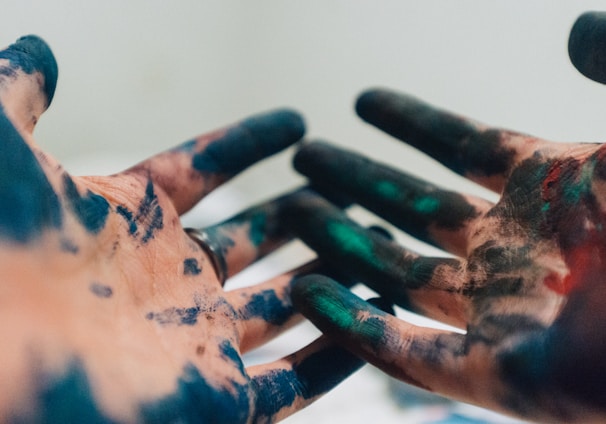 person hand with green and blue paint