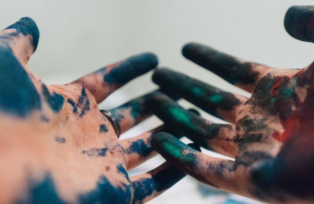 person hand with green and blue paint