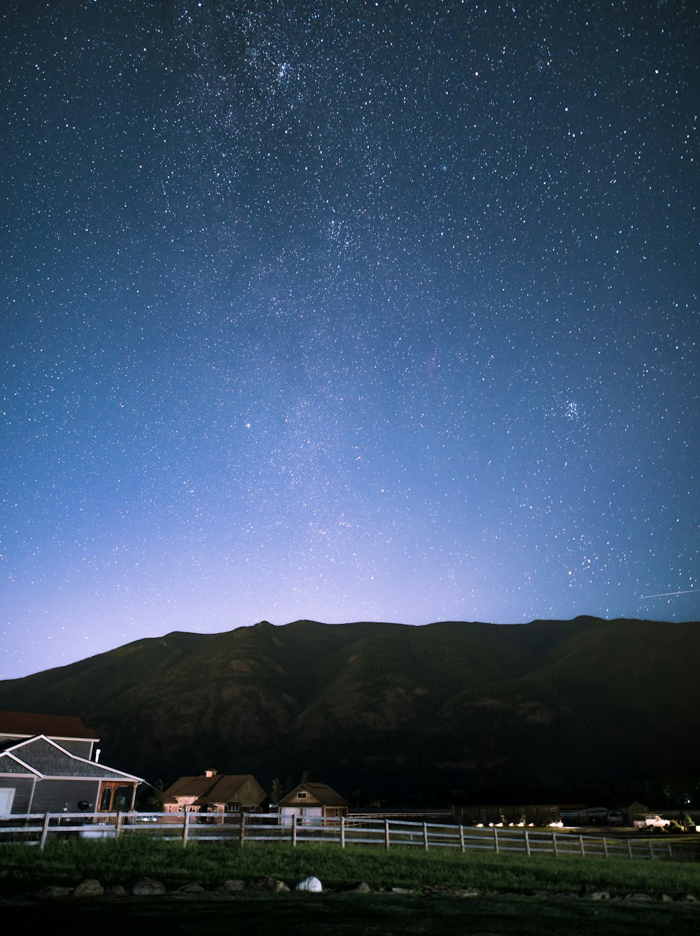 Casas marrones frente a la colina bajo la noche estrellada