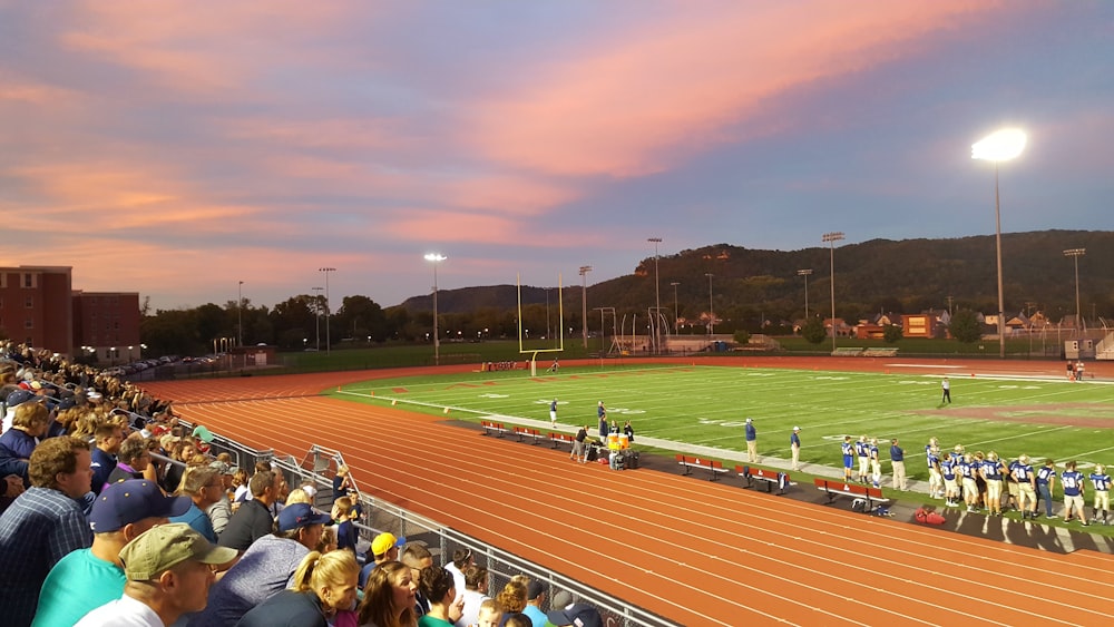 football players standing on field with crowd watching