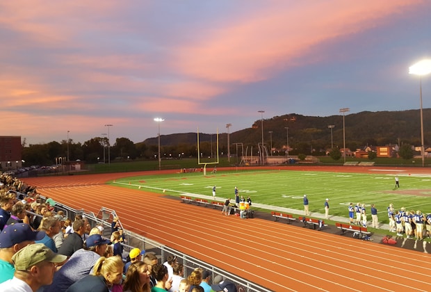 football players standing on field with crowd watching