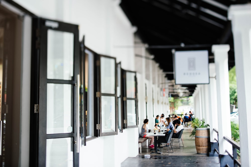 Personas sentadas en la terraza cerca de las ventanas durante el día