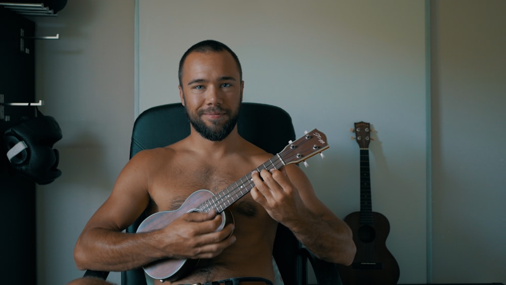 man in black tank top playing guitar