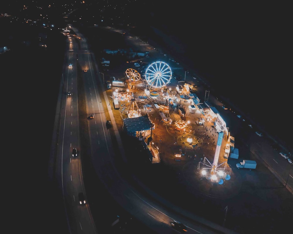 concrete roads with cars passing near amusement park