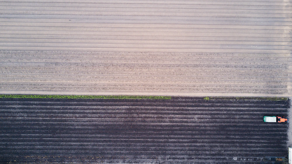 Vista aérea de campos agrícolas e de um trator