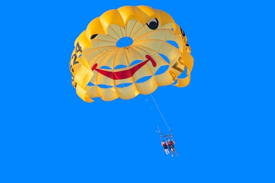 two person in yellow, red, and black parachute under blue sky during daytime in Punta de Torremolinos Spain
