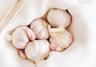 five garlic on white textile
