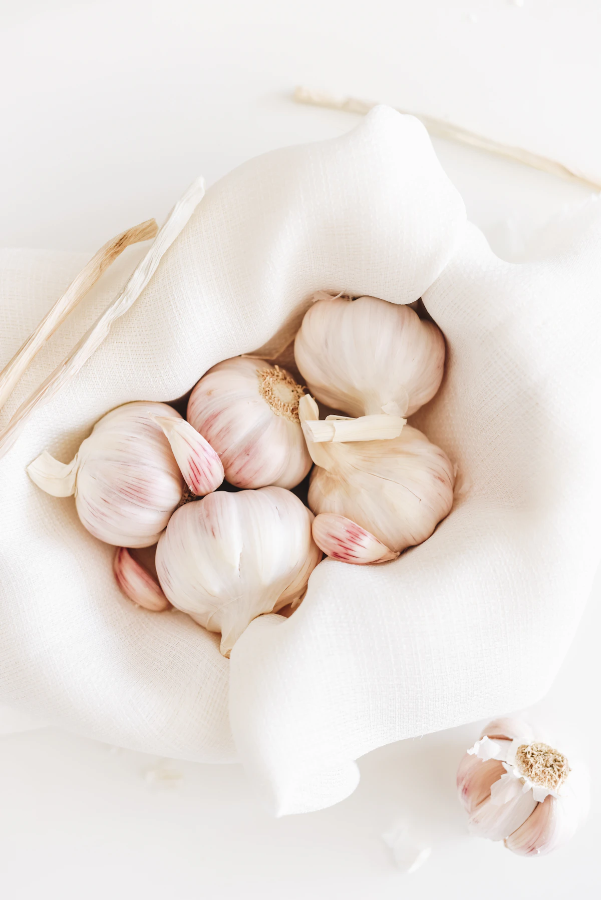 Five garlic on white textile
