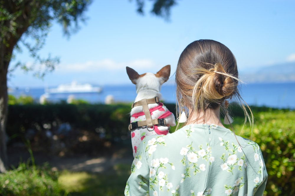 昼間、屋外で犬を運ぶ女の子