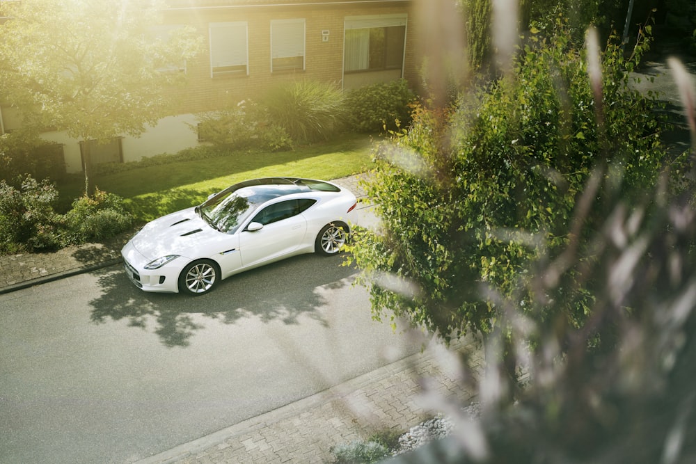 white coupe parked near house