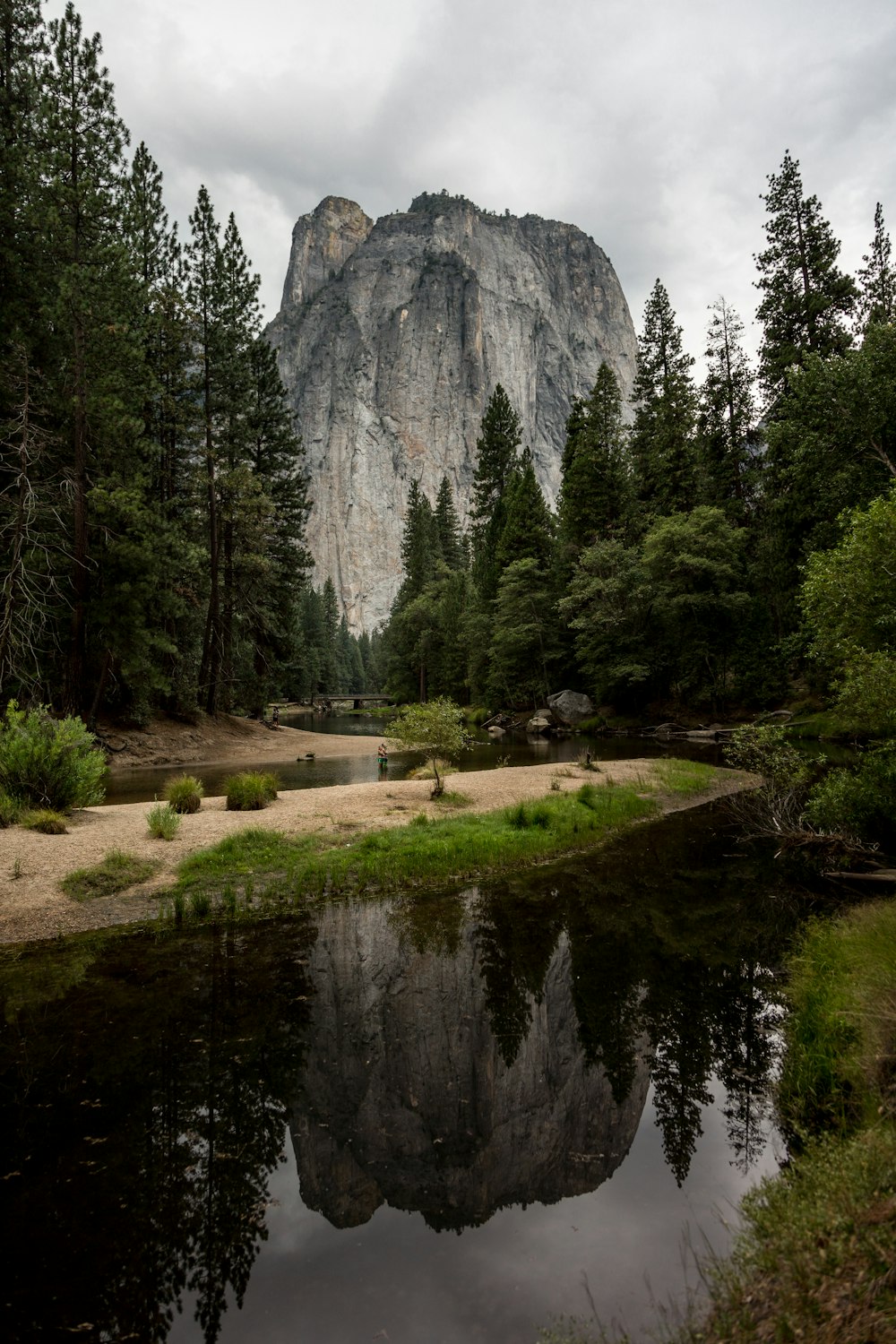 body of water near mountain at daytime