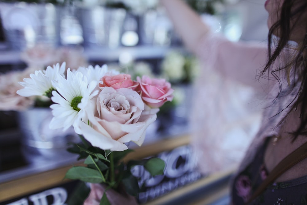 woman holding several assorted flowers