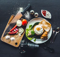 A flat lay of a calorie-tracked recipe spread with ingredients, a smartphone showing a tracking app, and cooking utensils.