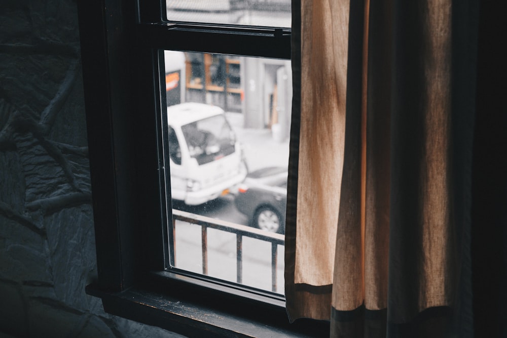 black sash window near brown curtain