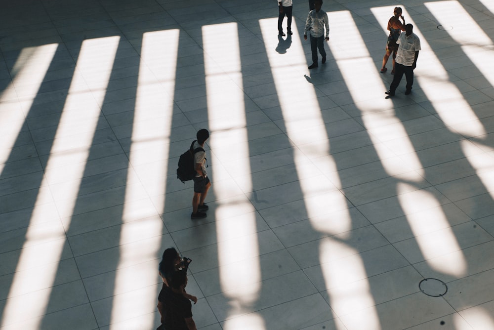 aerial photo of people walking on gray concrete pathway during daytime