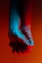 two person holding hands near orange background