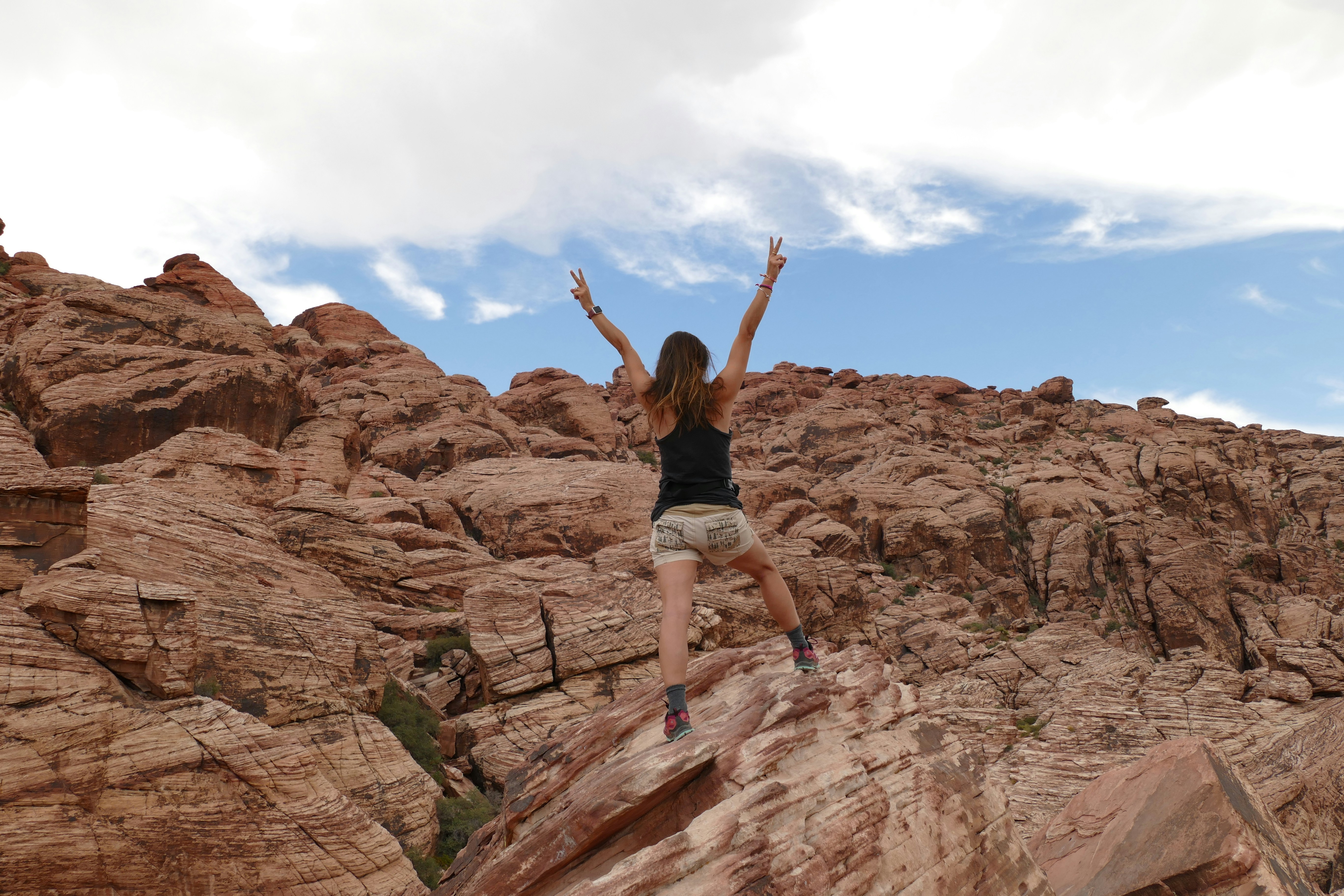 person in black tank top standing on mountain during daytime
