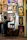 Artist at work sketching a custom portrait commission in a cozy studio.