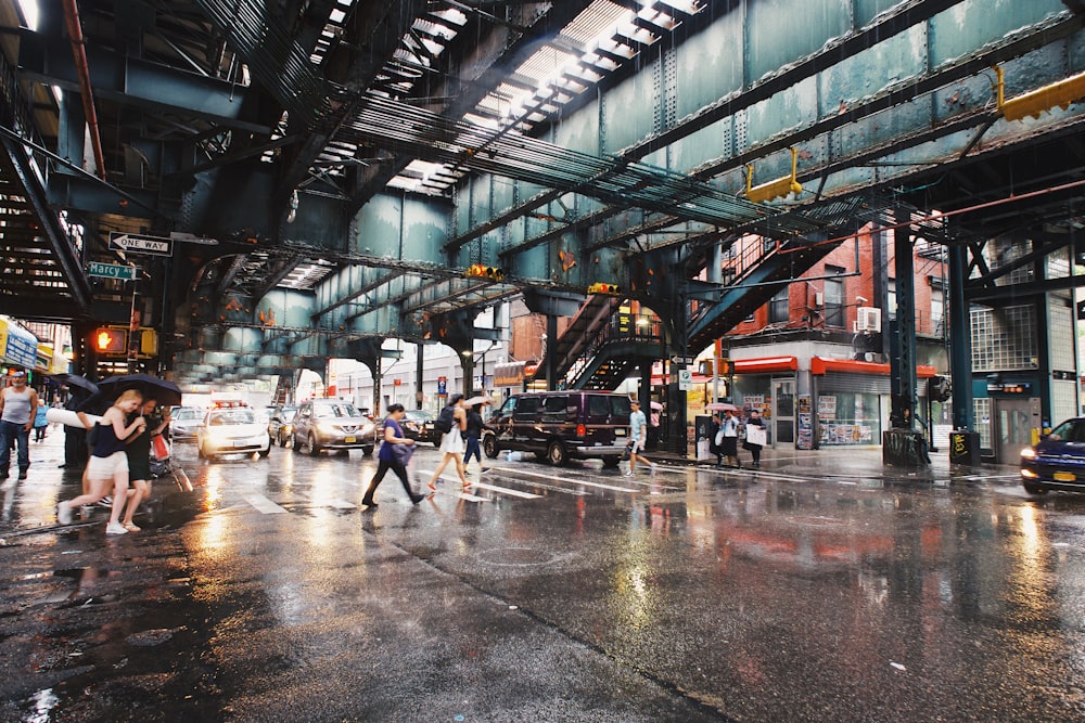 Eine Gruppe von Menschen, die im Regen eine Straße überqueren