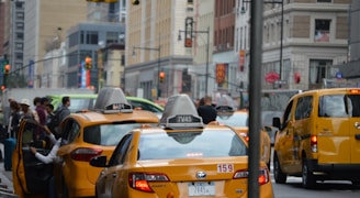 A busy street scene with taxis picking up passengers.