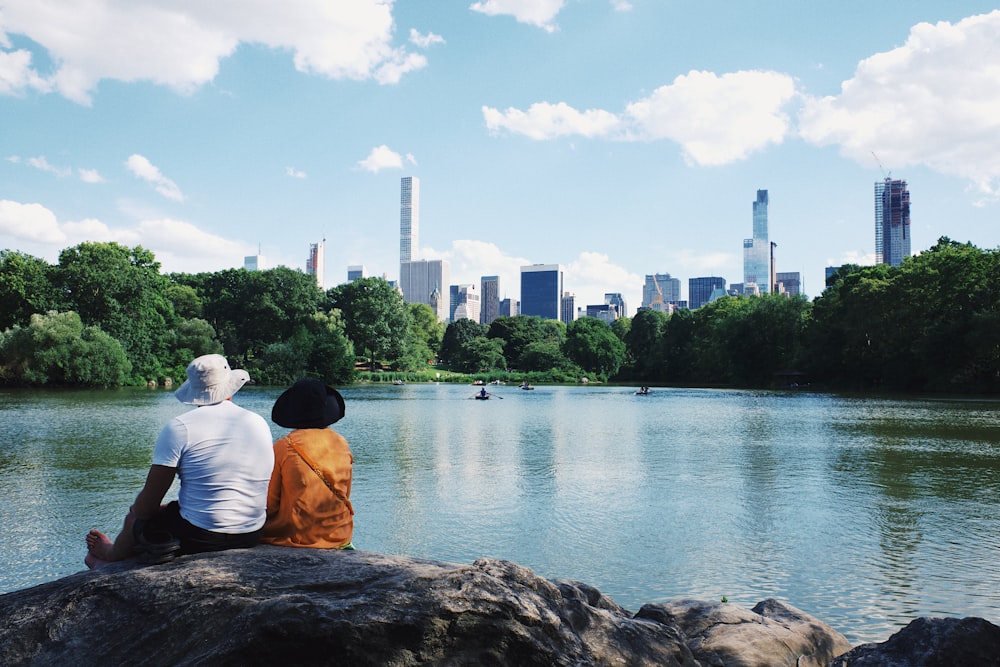 two person sits on gray stone