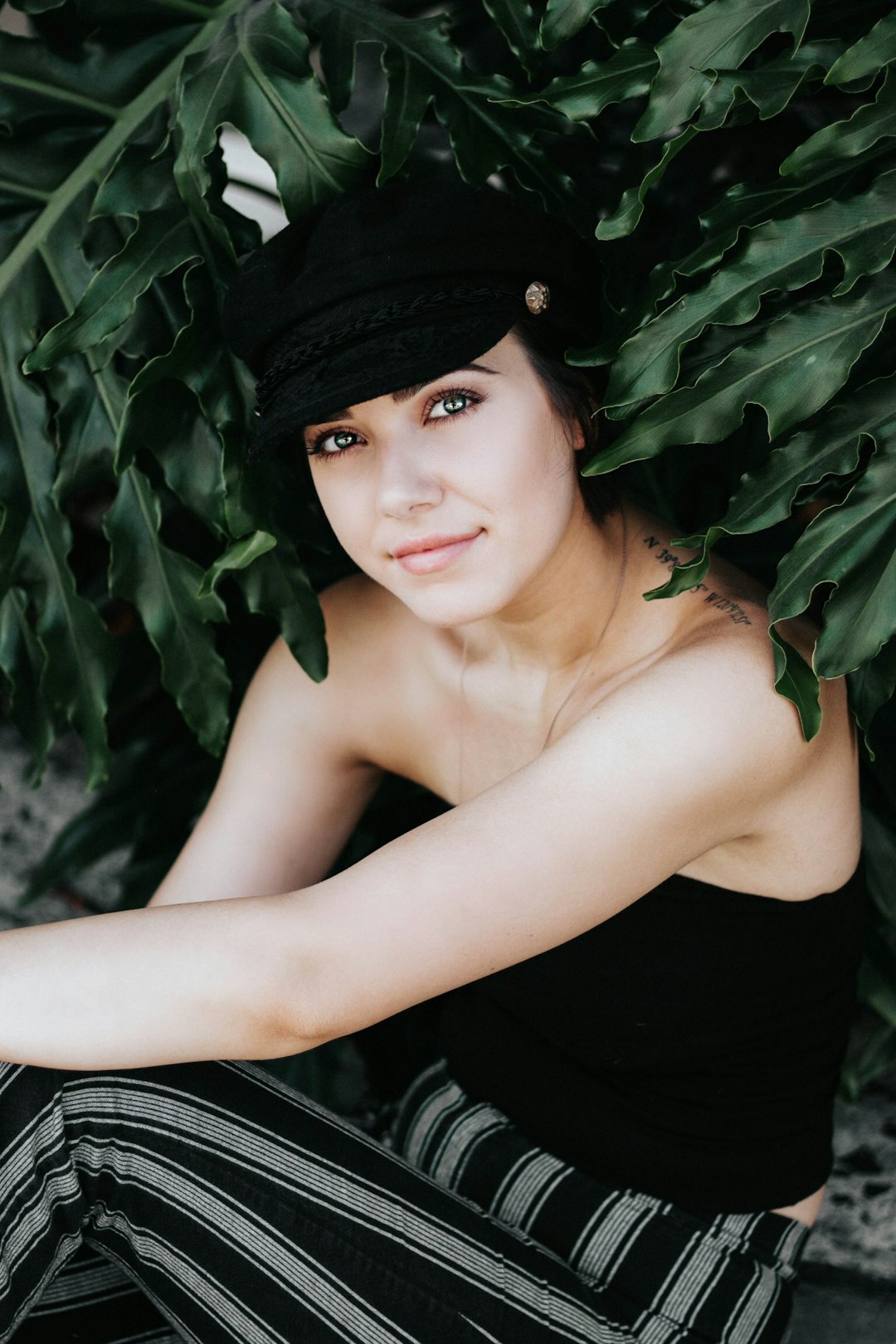 smiling woman in black strapless top and black and white striped pants