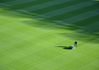 aerial photography of person trimming sports field during day