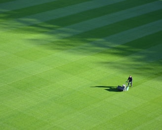 aerial photography of person trimming sports field during day